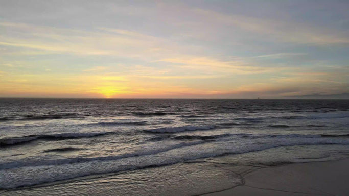 Drone Footage of slow motion sunset of the coast of Hermosa Beach